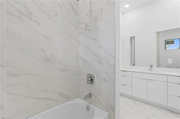 Bathroom featuring shower / washtub combination, vanity, and recessed lighting