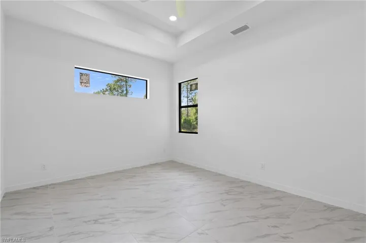 Spare room featuring light marble finish flooring and recessed lighting