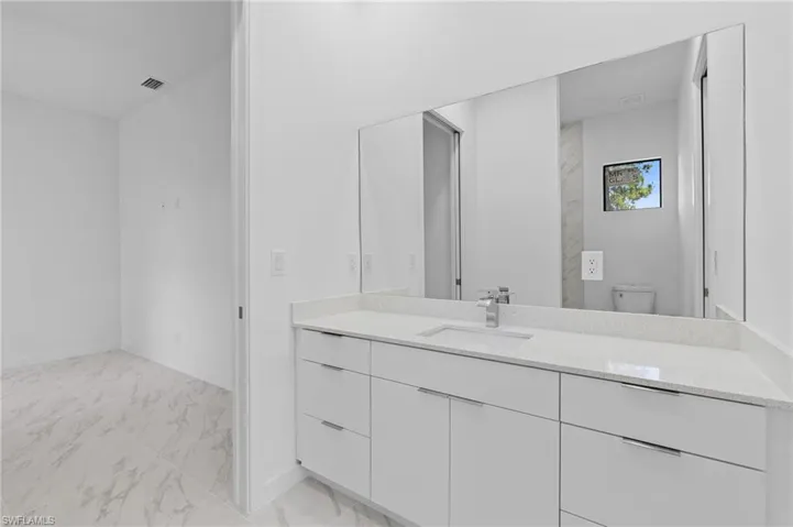 Full bathroom featuring vanity and light marble finish floors