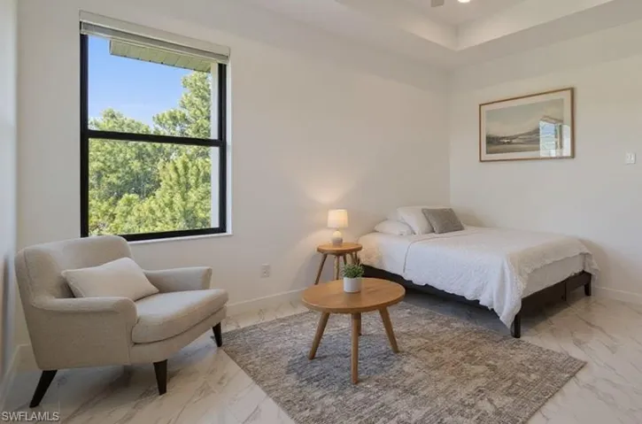 Bedroom featuring a tray ceiling, recessed lighting, ceiling fan, and marble finish floors
