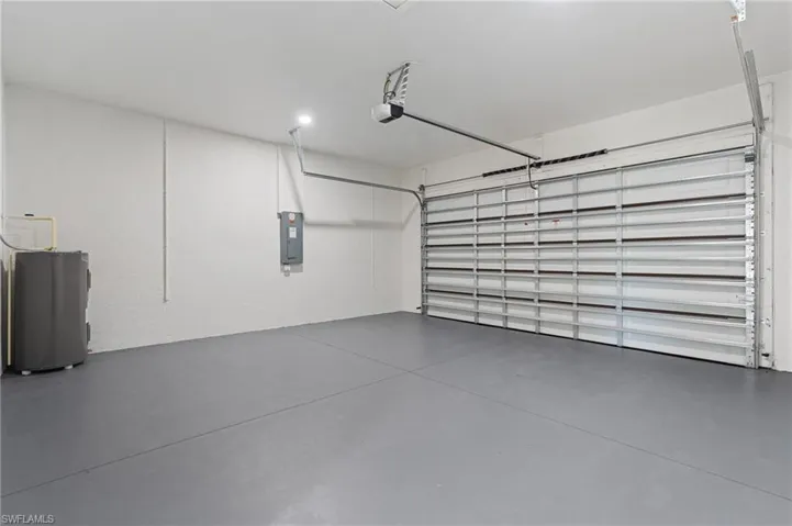 Garage featuring electric panel and water heater