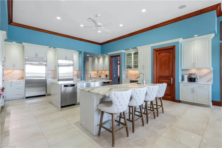 Kitchen featuring tasteful backsplash, ornamental molding, appliances with stainless steel finishes, a breakfast bar area, and recessed lighting