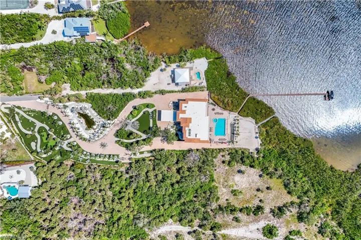 Aerial overview of property's location featuring a pool and a large body of water