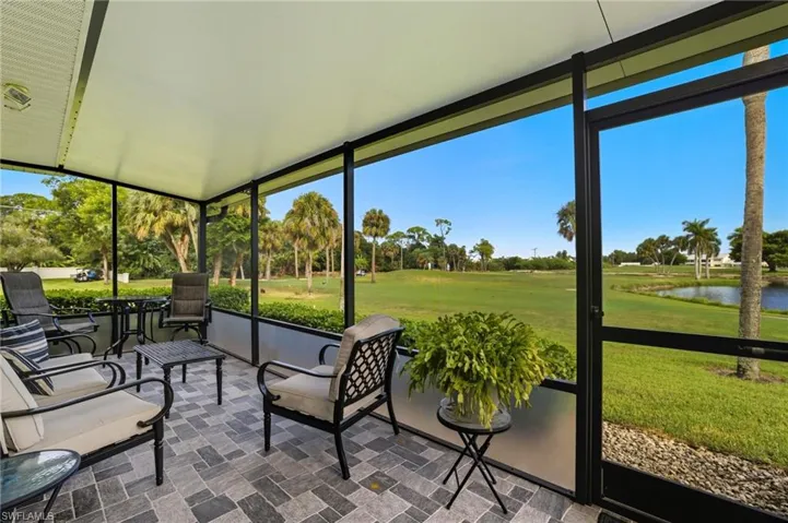 Sunroom / solarium featuring golf course view and a water view
