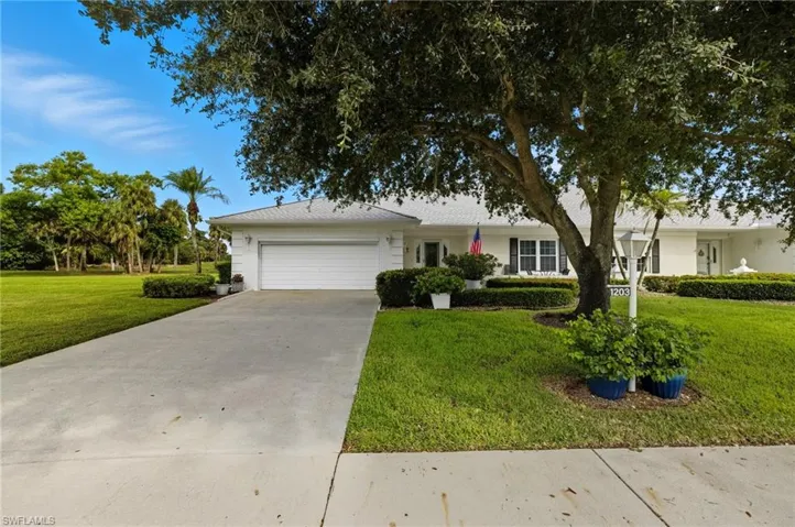 Single story home with a garage, a front lawn, and concrete driveway