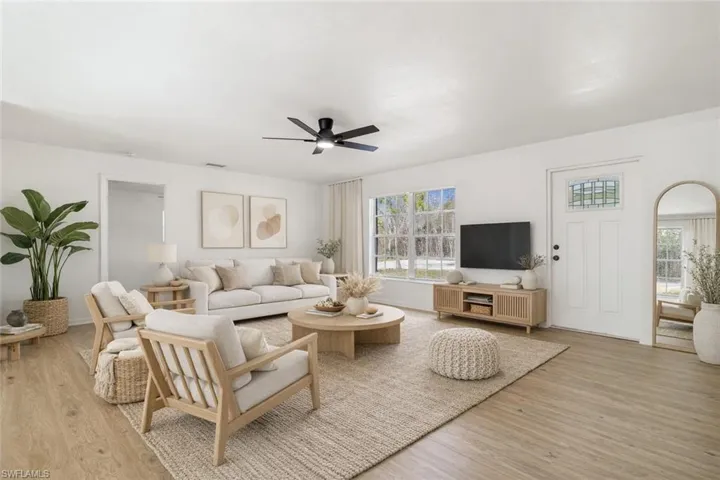 Living area with light wood-style floors-staged.