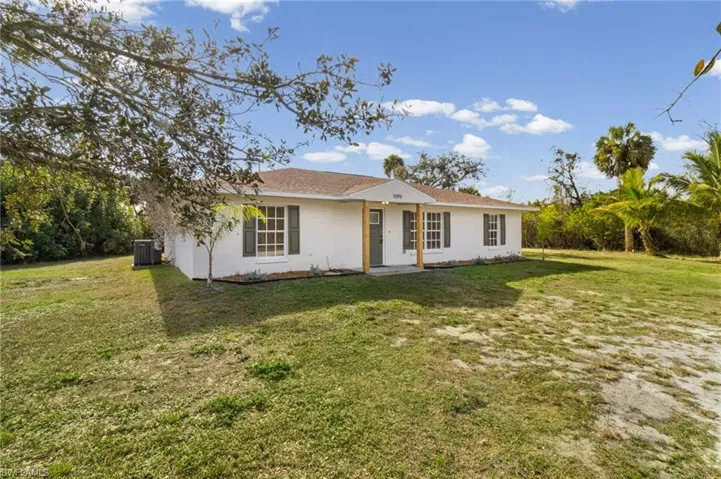 Ranch-style home with a front yard and stucco siding