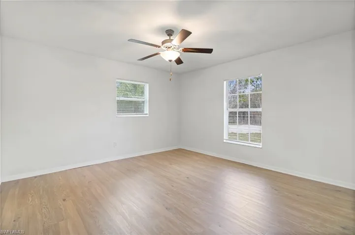 Empty room featuring light wood-style flooring and a ceiling fan