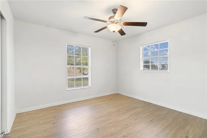 Empty room with light wood finished floors and a ceiling fan