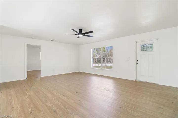 Unfurnished living room featuring light wood-style flooring and a ceiling fan