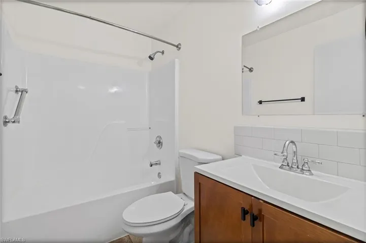 Full bathroom with vanity, decorative backsplash, and bathing tub / shower combination