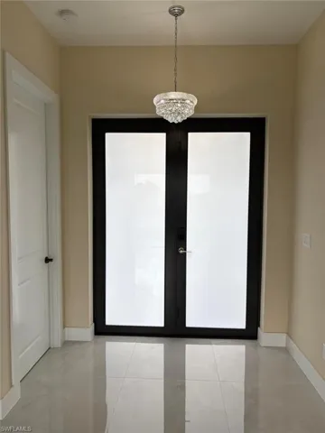 Entryway featuring french doors and light tile patterned floors