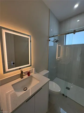 Bathroom with vanity, a shower stall, tile patterned floors, and recessed lighting