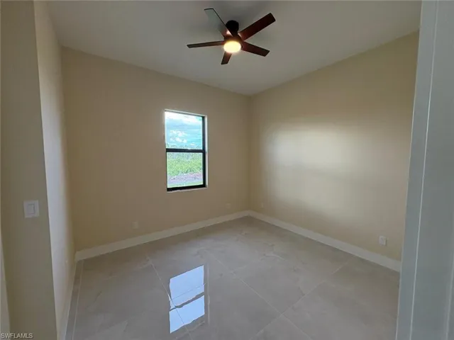 Unfurnished room with a ceiling fan and light tile patterned floors