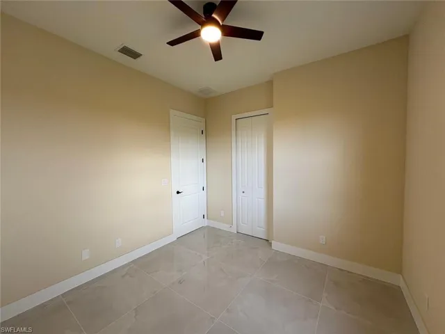 Spare room featuring light tile patterned floors and ceiling fan