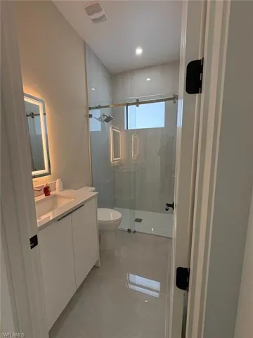 Bathroom with vanity, a stall shower, and recessed lighting