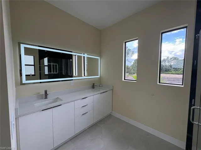 Bathroom featuring double vanity and a shower with shower door