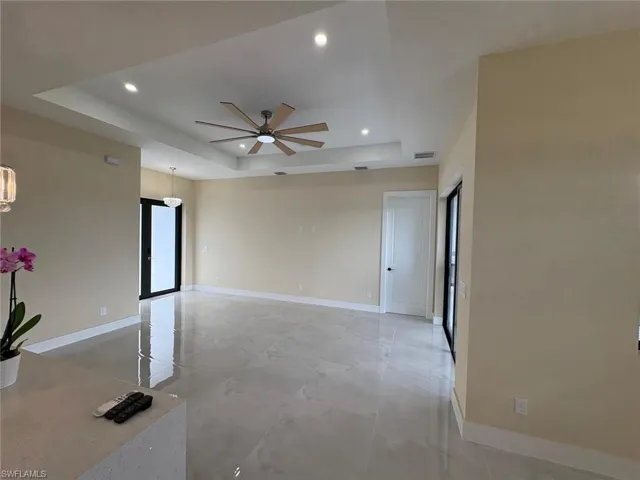 Unfurnished room with a raised ceiling, recessed lighting, and ceiling fan