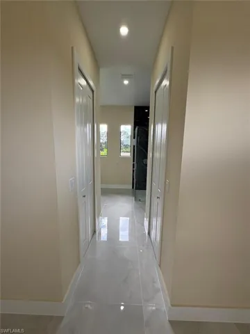 Hall with baseboards and recessed lighting