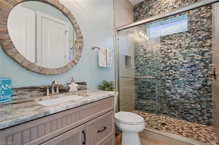 2nd Full bath with a tiled shower stall, glass sliding doors, toilet, and vanity