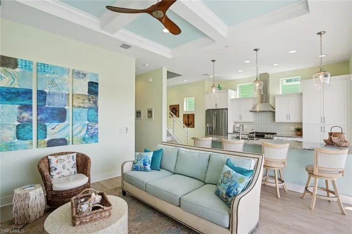 Living room with beamed ceiling, coffered ceiling, and a ceiling fan