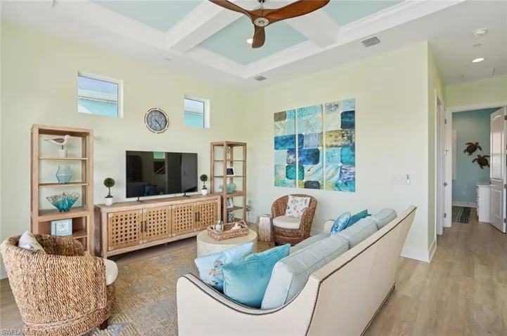 Living room area with  ceiling fan, beam ceiling, luxury vinyl floors, and coffered ceiling