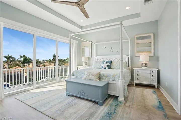 Luxurious Master Bedroom with access to exterior balcony, LVF flooring, baseboards, and ceiling fan