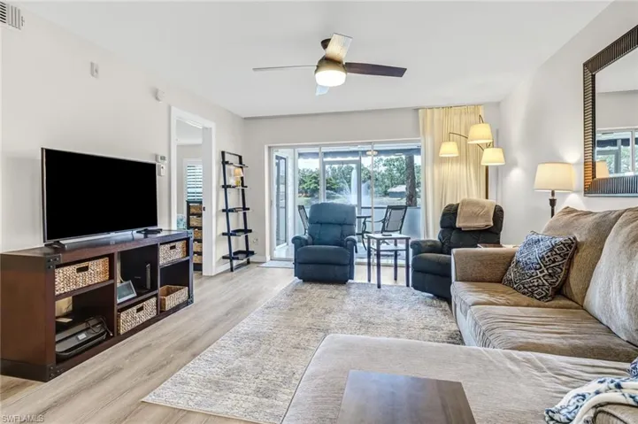Living room with ceiling fan, light hardwood / wood-style floors, and a wealth of natural light
