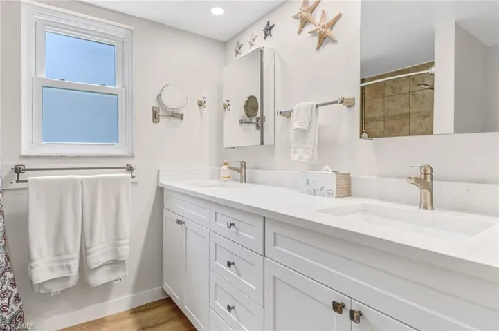 Bathroom with double vanity and hardwood / wood-style flooring