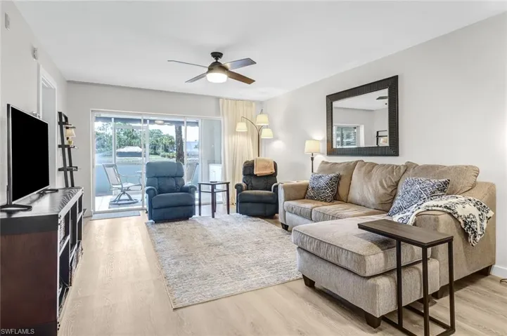 Living room with ceiling fan and light hardwood / wood-style flooring