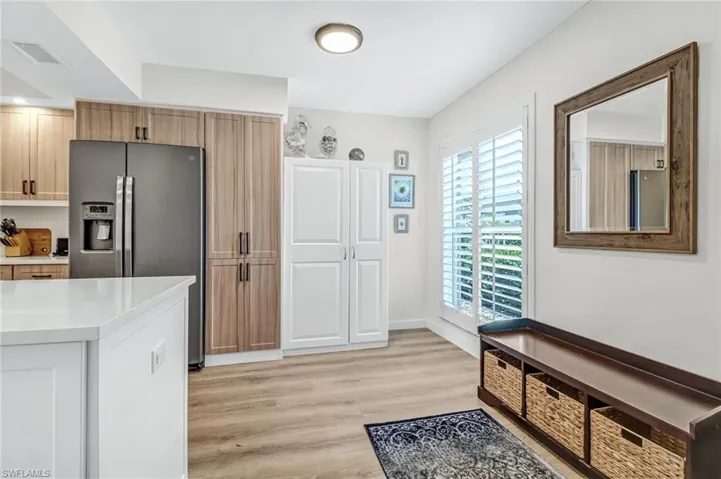 Kitchen featuring stainless steel fridge with ice dispenser, stainless steel refrigerator, and light wood-type flooring