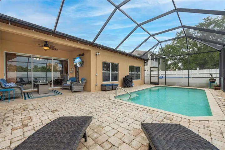 View of pool featuring outdoor living space, a patio area, and ceiling fan