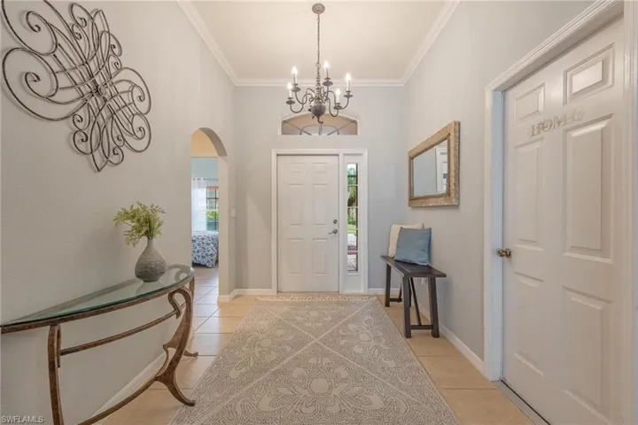Tiled entrance foyer. Arch to left leads to 2 bedrooms, full bath and laundry room. Door on right is the garage entrance. Light and bright throughout.