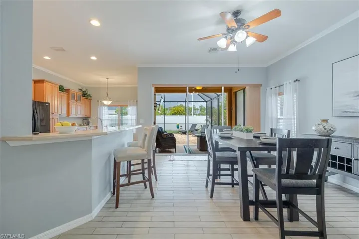 Such a room dining room - adjacent to huge eat-in kitchen. Loads of flexibility with the breakfast bar and sliders to covered lanai and pool!