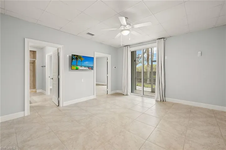 3rd bedroom with ceiling fan, light tile patterned floors, and a paneled ceiling