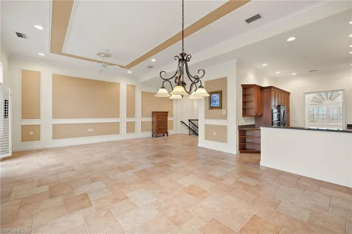 Dining Area featuring decorative light fixtures, a tray ceiling, ornamental molding, and ceiling fan with notable chandelier