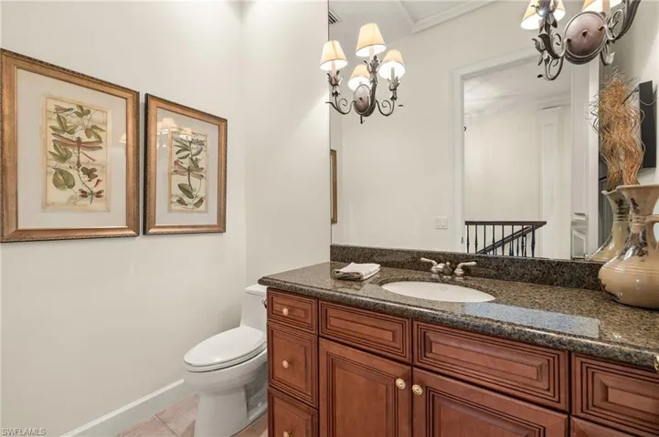 Half Bathroom with toilet, vanity, and tile patterned floors