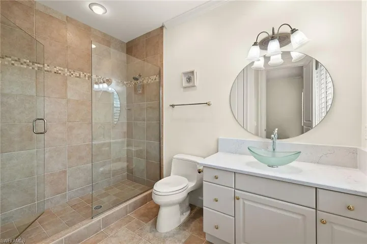 2nd full Bathroom featuring a shower with shower door, toilet, vanity, and ornamental molding
