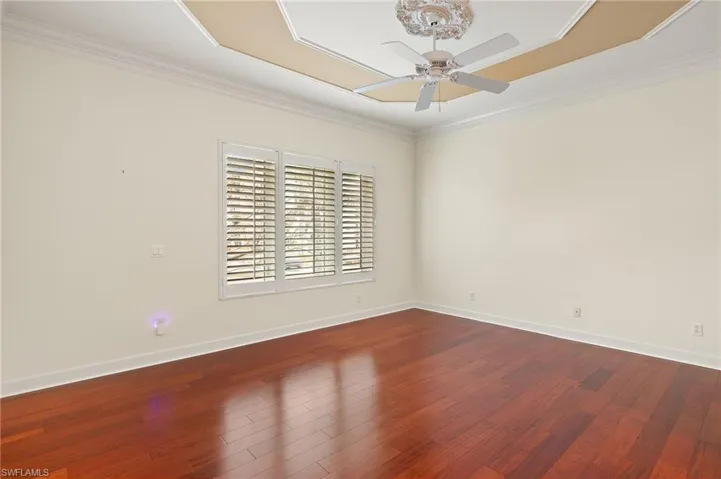 Master Bedroom featuring wood flooring, plantation shutters, ceiling fan, wood-type flooring, and ornamental molding