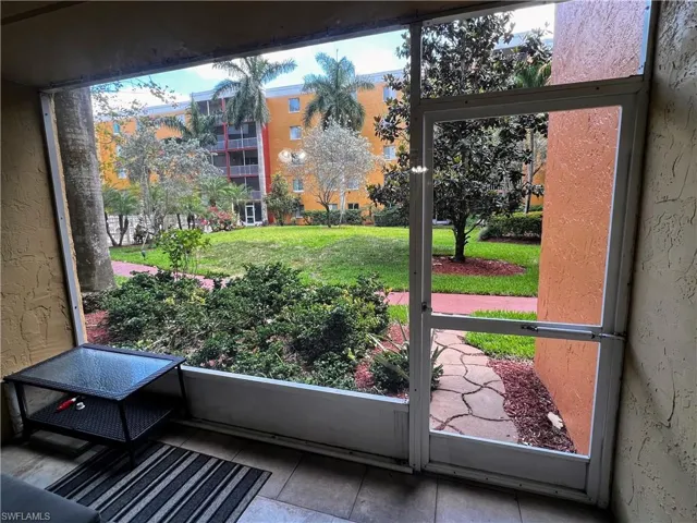 Doorway to outside featuring tile patterned floors, a textured wall, and plenty of natural light