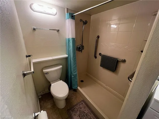 Full bathroom with toilet and tiled shower