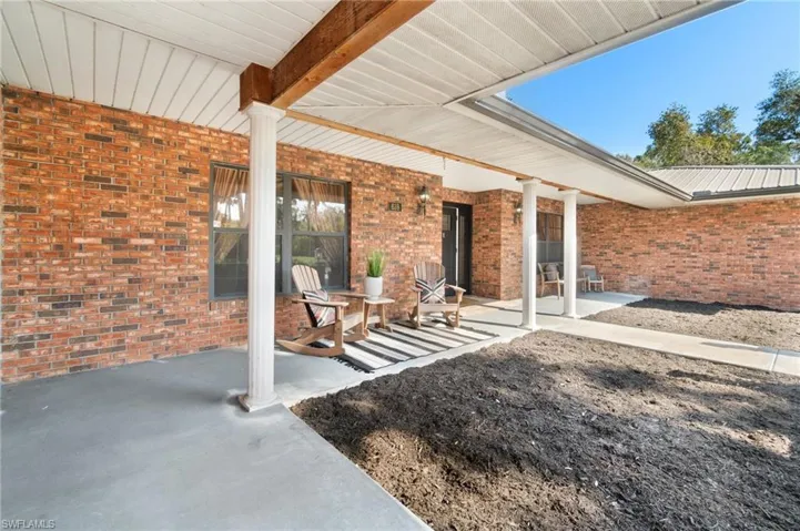 View of exterior entry with extended covered porch to watch the deer and turkey graze