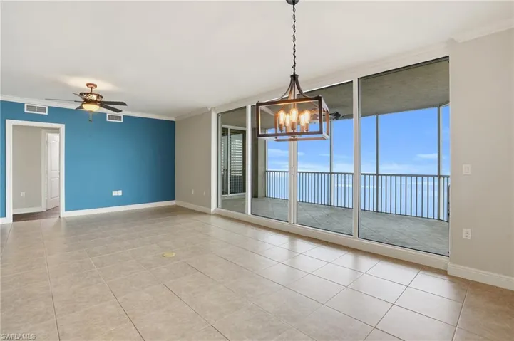 Dining/Living area with floor to ceiling windows, a ceiling fan, crown molding, a chandelier, and light tile floors