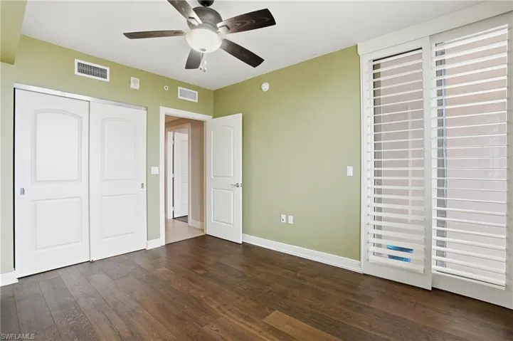 2nd bedroom featuring hard wood flooring, ceiling fan, and a closet