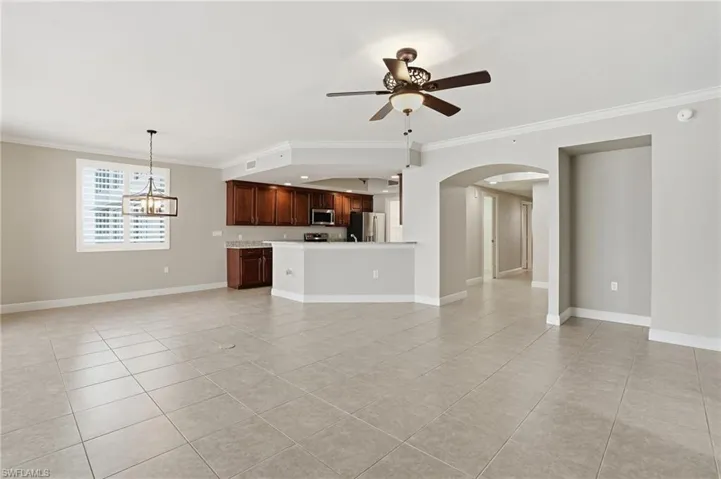 Living/Dining area room featuring floor to ceiling windows, ornamental molding, ceiling fan, and light tile floors