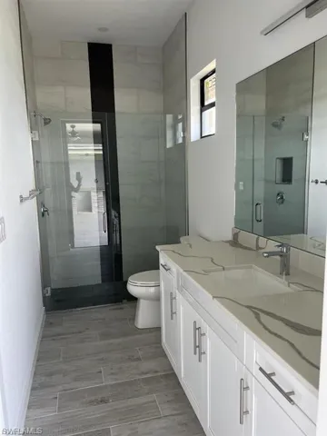 Bathroom featuring vanity, a stall shower, and wood tiled floors