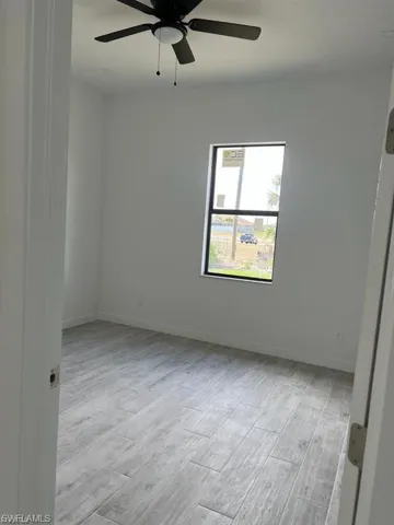 Empty room featuring light wood finished floors and a ceiling fan