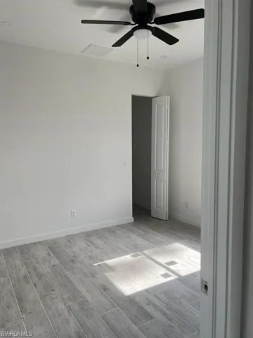 Empty room featuring wood tiled floors and a ceiling fan