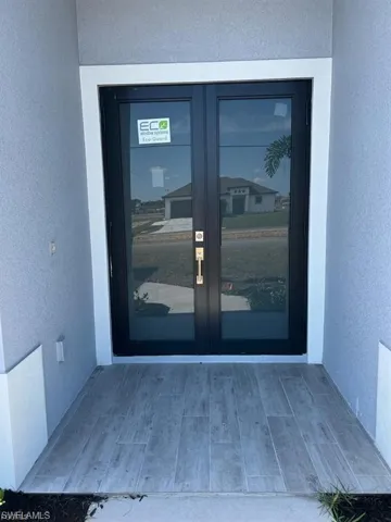 Doorway to property with french doors and stucco siding