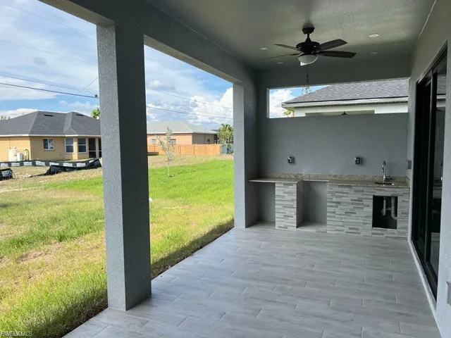 View of patio with exterior kitchen and ceiling fan